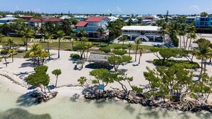A coastal resort with beachfront properties, palm trees, and a clear sky. - Island pool home awaits in Islamorada's Port Antigua (Islamorada)