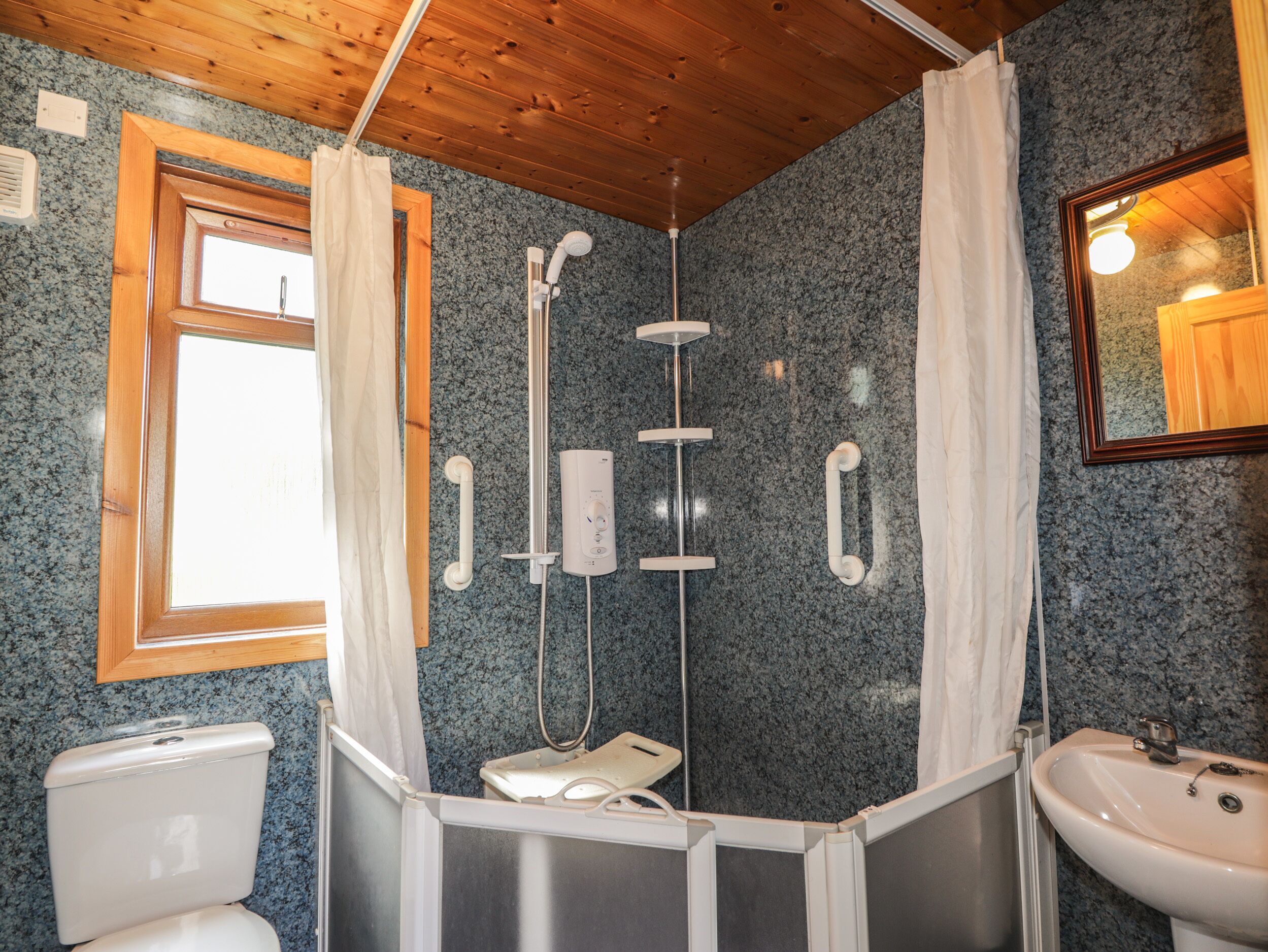 A bathroom with a shower, toilet, and sink.