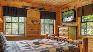 A wooden cabin room with a bed, a television, and windows with curtains. - 2 Bedroom/2 Bathroom Cabin, PRIVATE! (Sevierville)