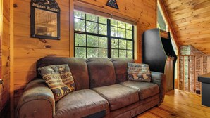 A wooden cabin interior with a leather couch, a billiard table, and a large window. - 2 Bedroom/2 Bathroom Cabin, PRIVATE! (Sevierville)