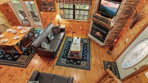 A cozy cabin interior with a dining area, sofa, fireplace, and a TV. - 2 Bedroom/2 Bathroom Cabin, PRIVATE! (Sevierville)