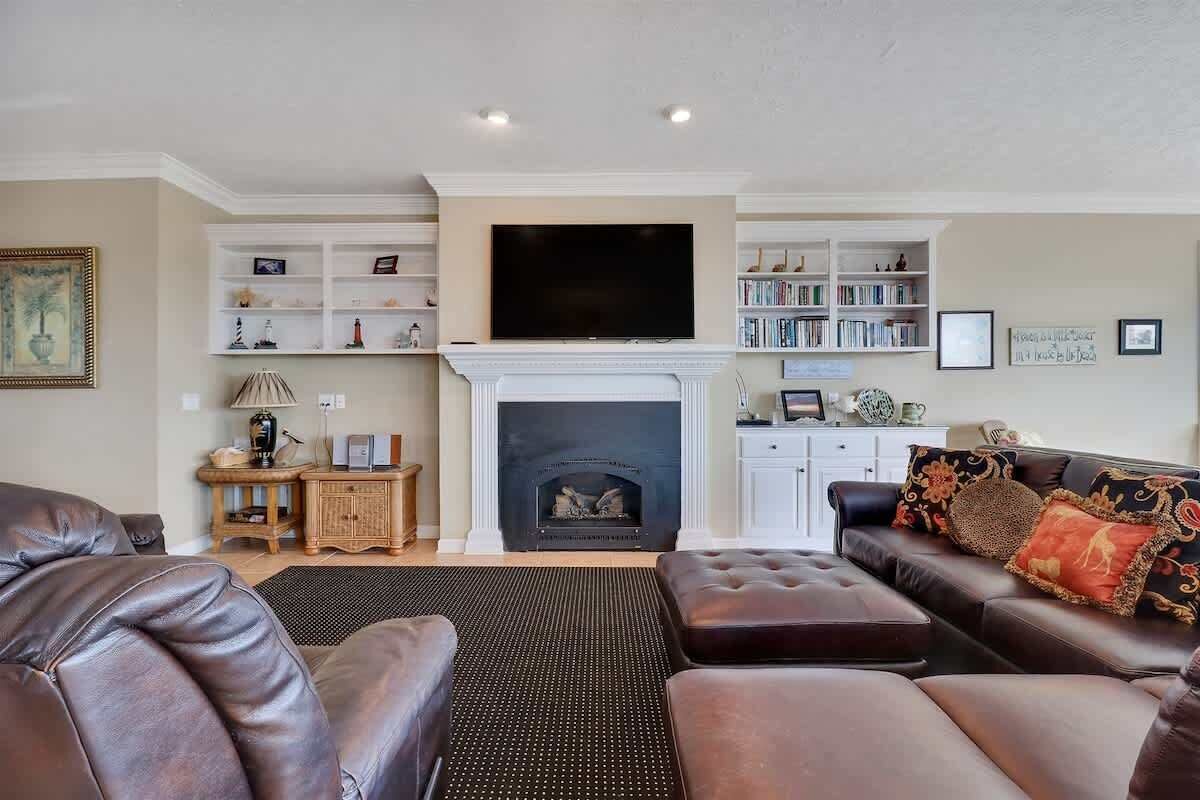 A living room with a fireplace, a television, and a bookshelf.
