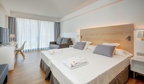 A hotel room with a large bed, a desk, a chair, and a view of the outdoors through sheer curtains. - Hotel Girasol (Sant Llorenc des Cardassar)