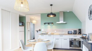 Una cocina moderna con comedor, microondas, cafetera y horno.