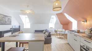 Een moderne keuken met een eetgedeelte, houten vloeren en een loft-achtige plafond.