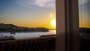 A sunset view from a balcony overlooking a harbor with boats and a distant town. - Apartments Tayra - Comfort Studio with Balcony (BR3) (Dubrovnik)