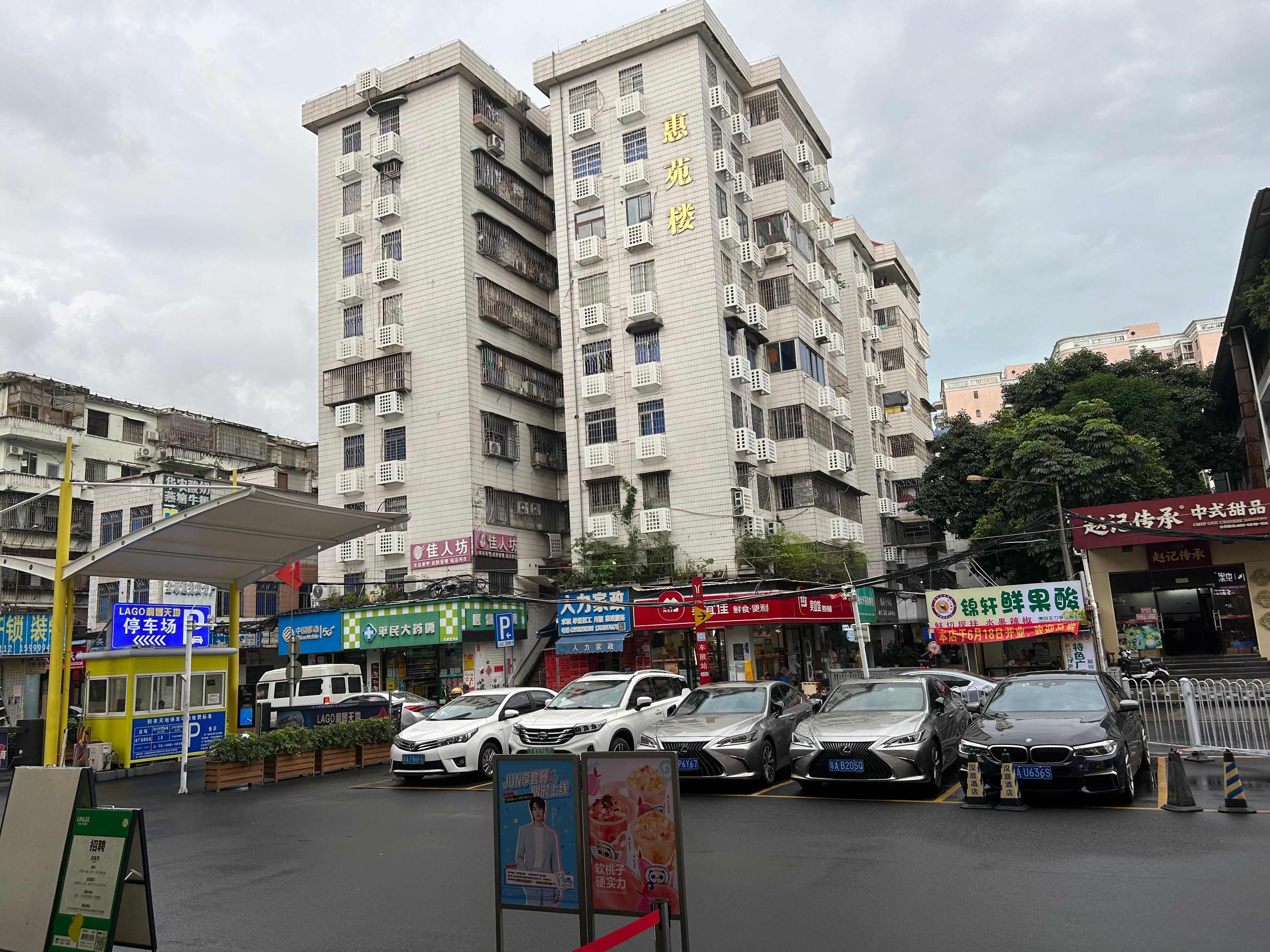 A multi-story building with commercial establishments on the ground floor and residential units above.