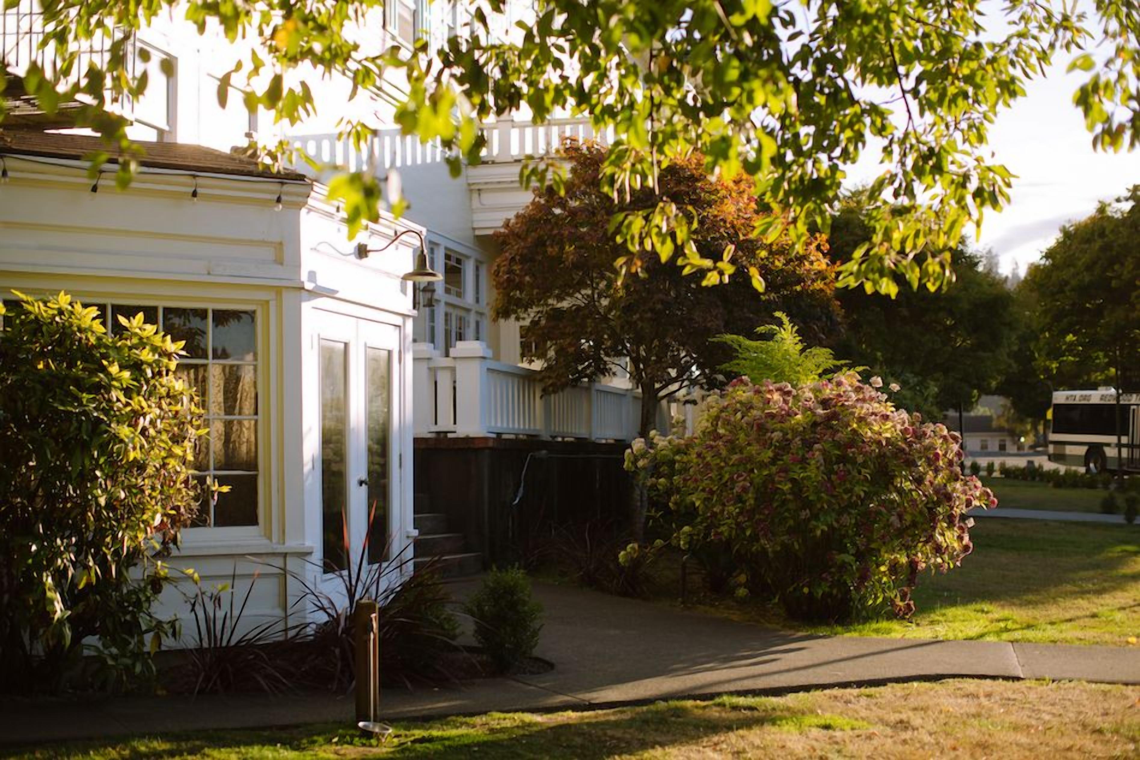 Une maison d’habitation avec un jardin devant, un garage et une allée.