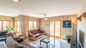 A spacious living room with a stone wall, a sofa, a chair, and a coffee table.