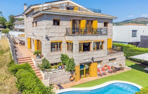 A multi-story stone building with a pool, outdoor seating, and a view of the surrounding landscape. - Amazing home in Alella (Alella)