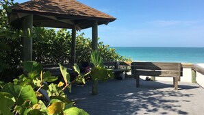 A wooden gazebo with a tiled roof overlooking a beach. - Beachfront 3/2 Penthouse Lido Key Beautiful Views! (Sarasota)