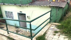 Il s’agit d’un petit bâtiment d’un seul étage, à l’extérieur vert et doté d’un toit en tuiles. On y trouve une porte avec une fenêtre, un petit espace extérieur agrémenté d’une rambarde en métal et une plaque indiquant l’adresse, bien visible.