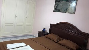 Una camera da letto con un letto, un comodino, un armadio e un quadro appeso al muro.