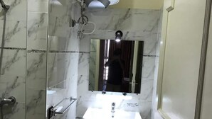 Un bagno piccolo con un lavandino su piedistallo, uno specchio e un termosifone a parete.