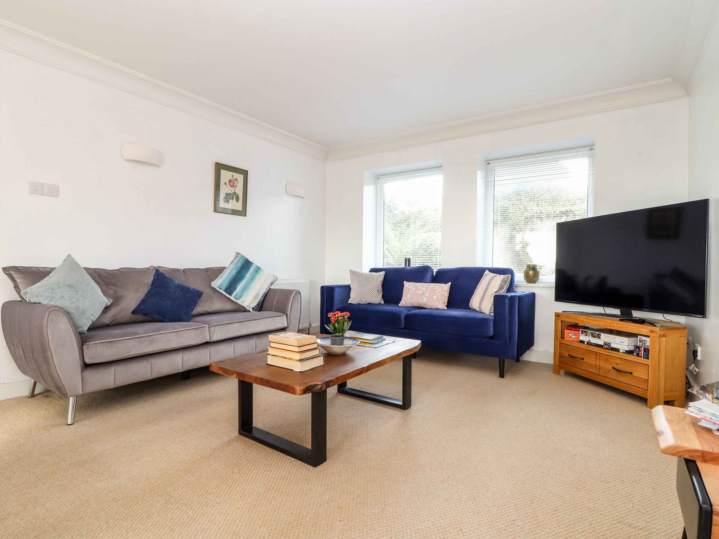 A living room with two sofas, a coffee table, a TV, and a bookshelf.