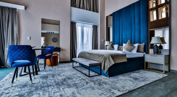 A modern hotel room with a large bed, a desk, and a chair. - Elexus Poiana Brasov (Brasov)