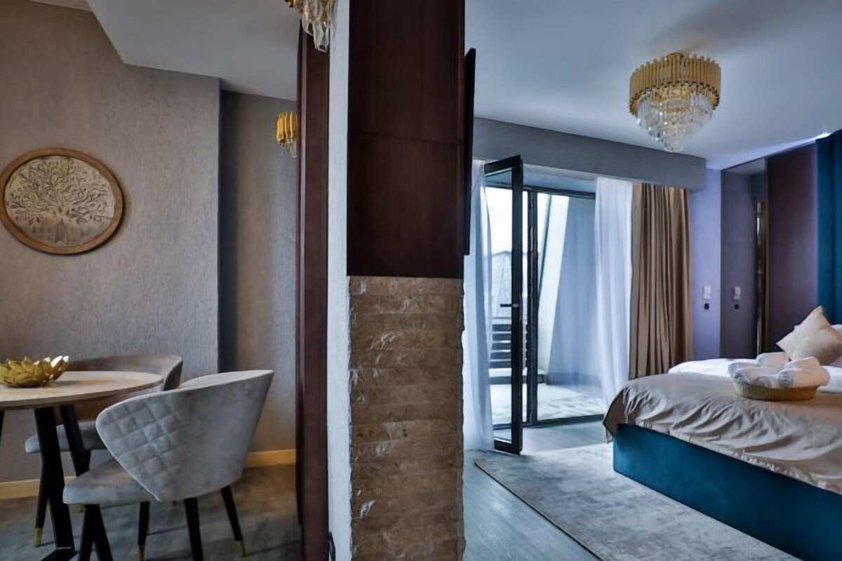 A hotel room with a bed, a desk, and a chair.