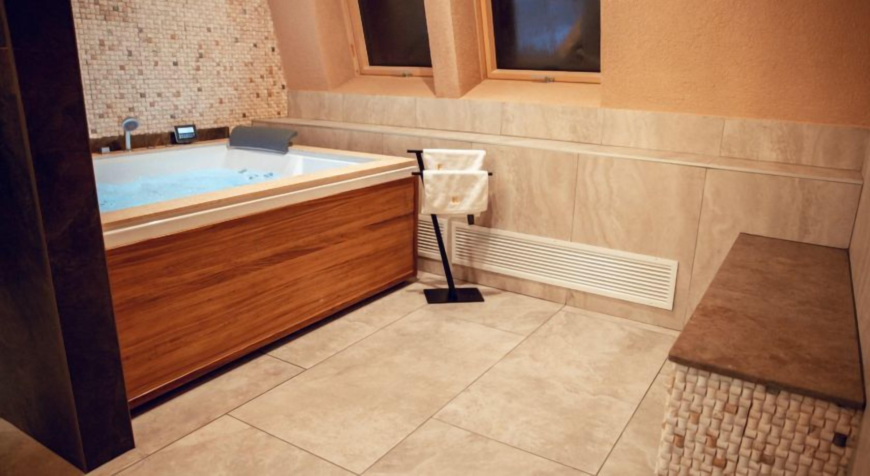 A modern bathroom with a wooden vanity, a bathtub, and a towel rack.