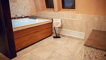 A modern bathroom with a wooden vanity, a bathtub, and a towel rack.