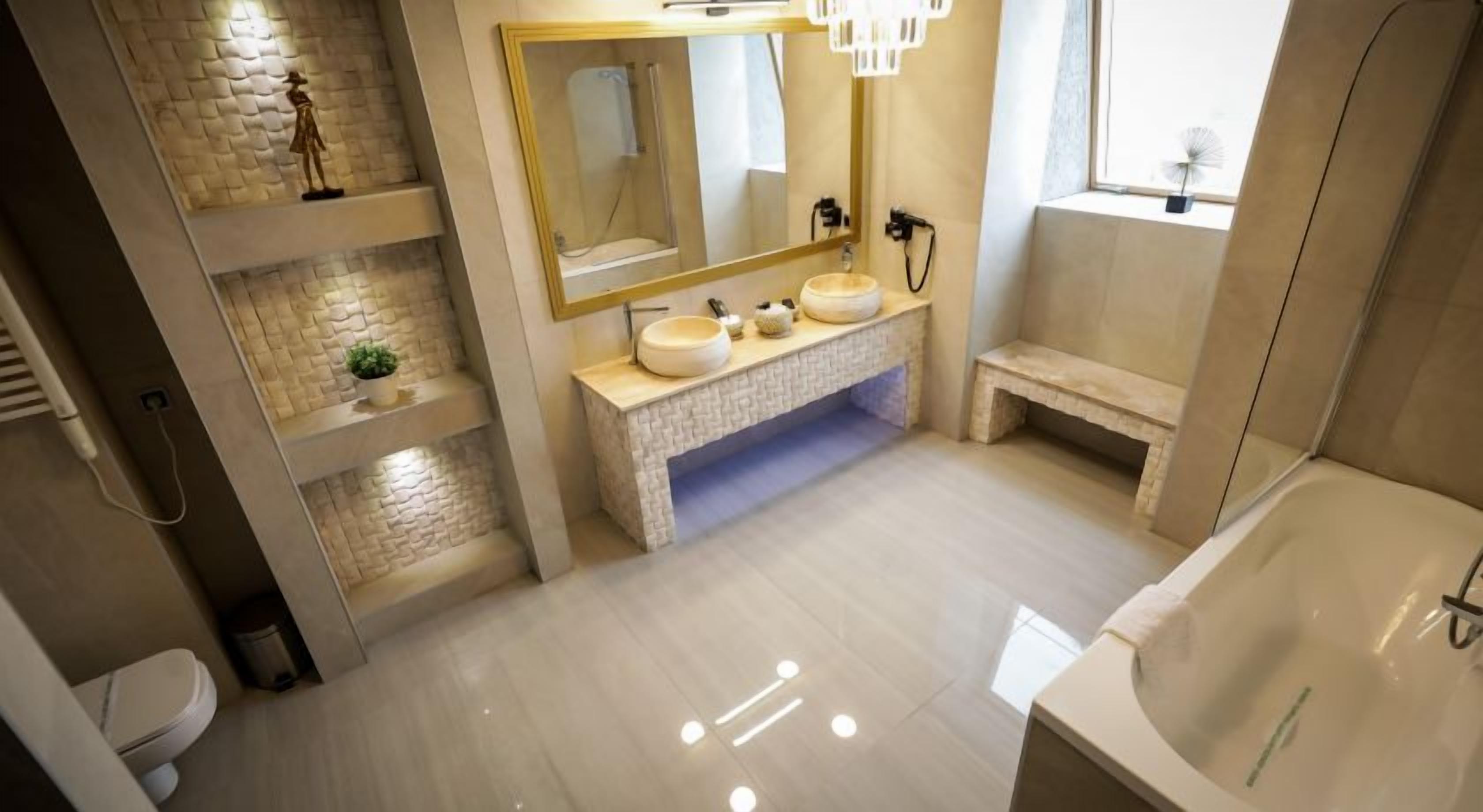 A modern bathroom with a stone sink vanity, a large mirror, and a bathtub.