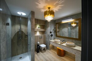A modern bathroom with a walk-in shower, a toilet, a sink with a large mirror, and a chandelier. - Elexus Poiana Brasov (Brasov)