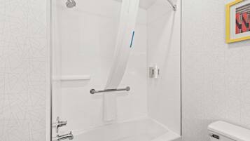 A modern bathroom with a glass-enclosed shower, a bathtub, and a toilet.