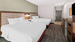 A hotel room with two beds, a desk, and a TV. - Hampton Inn Longview (Longview)