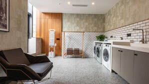 A modern laundry room with a washing machine, dryer, and a drying rack. - Greentree Eastern Suzhou Dushu Lake Guoyuan Road Subway Station Hotel (Suzhou)