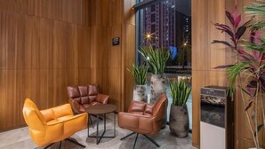 A modern lobby with leather sofas, a marble floor, and large windows overlooking a cityscape. - Greentree Eastern Suzhou Dushu Lake Guoyuan Road Subway Station Hotel (Suzhou)