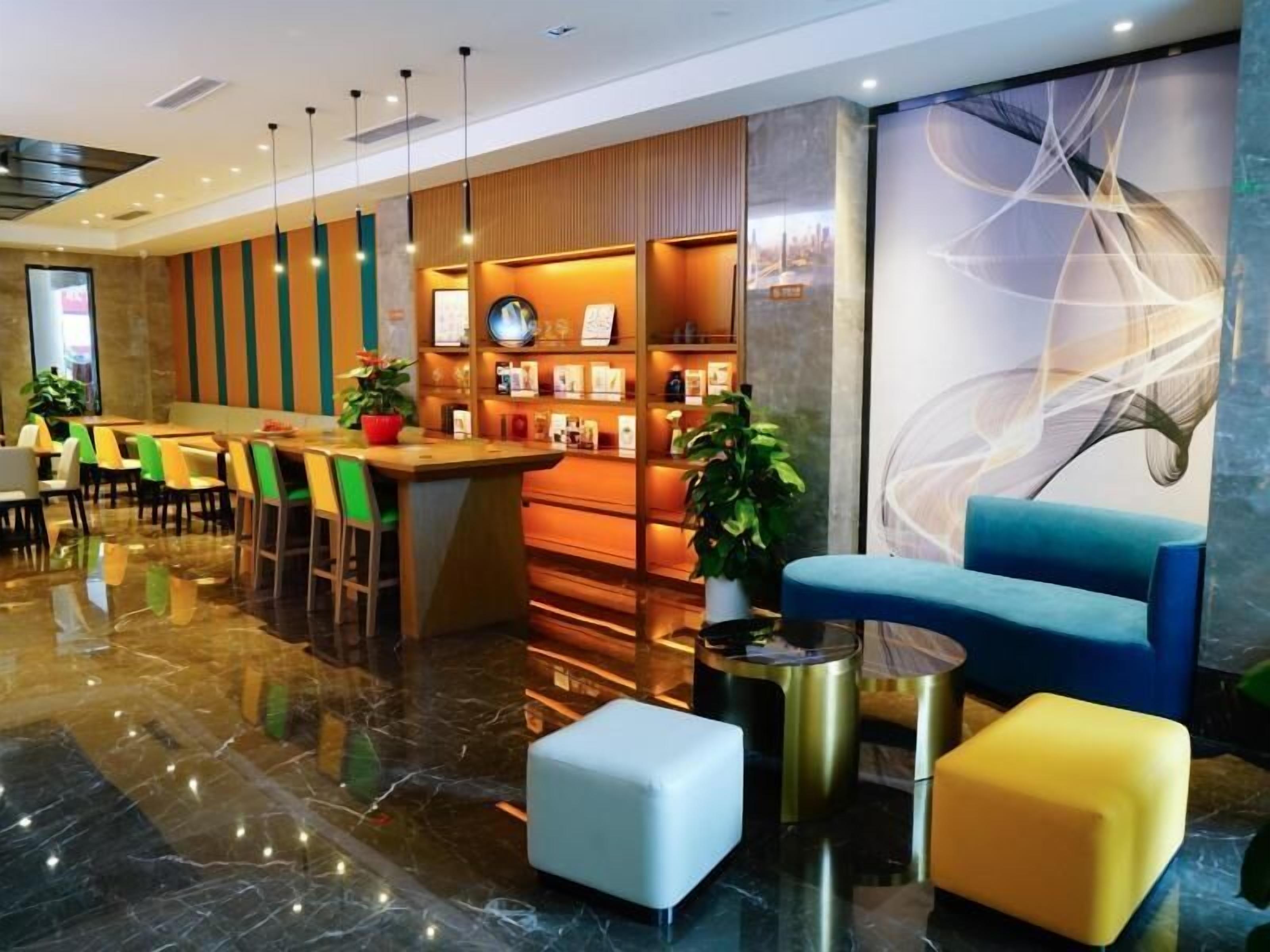 Een moderne hotellobby met een bar, zitplaatsen en een groot abstract schilderij.