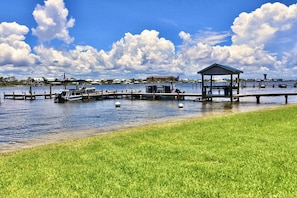 A marina with boats docked, a covered pavilion, and a grassy area.