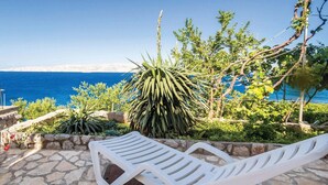 A stone patio with white lounge chairs overlooking a coastal view. - Gorgeous apartment in Senj with house sea view (Senj)