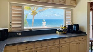 A kitchen with a view of the ocean, a microwave, and a coffee maker on the counter. - Caribbean Island Retreat, 200 degree water views, trade winds and soothing waves (Christiansted)