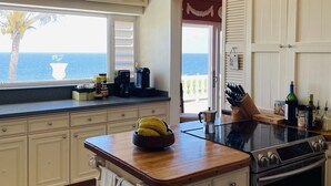 A kitchen with a view of the ocean, a stove, and a window with blinds. - Caribbean Island Retreat, 200 degree water views, trade winds and soothing waves (Christiansted)