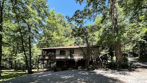 A cabin with a deck and stairs, surrounded by trees. - Happy mtn. home, enjoy 7 acres & 2 ponds, 1/2 mile to DuPont State Forest gate! (Cedar Mountain)
