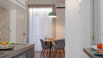 Een koelkast, een magnetron, een vaatwasser, kookgerei, borden en bestek