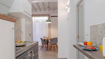 Een koelkast, een magnetron, een vaatwasser, kookgerei, borden en bestek