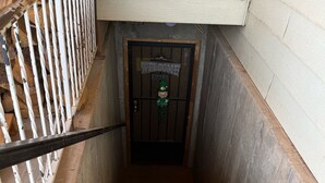 A staircase leading to a door with a 'WELCOME' sign and a leprechaun decoration. - Grandma Marva’s Hideout basecamp for many National & State Parks (Blanding)