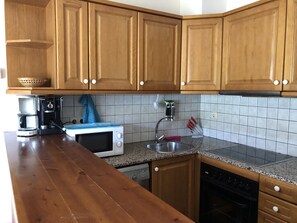 Een koelkast, een oven, een koffiezetapparaat/waterkoker, een waterkoker