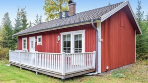 A red wooden house with a white porch, a chimney, and a number 139 sign.