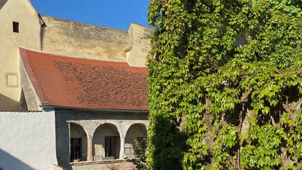 A building with a red-tiled roof, white walls, and a courtyard with arches. - Vacation domicile - Comfortable vacation apartment OG1 for 1-5 pers. Central. Terrace. (Bad Radkersburg)