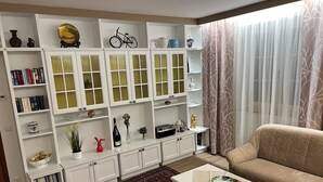 A living room with a sofa, a coffee table, a bookshelf, and a patterned rug. - Vacation domicile - Comfortable vacation apartment OG1 for 1-5 pers. Central. Terrace. (Bad Radkersburg)