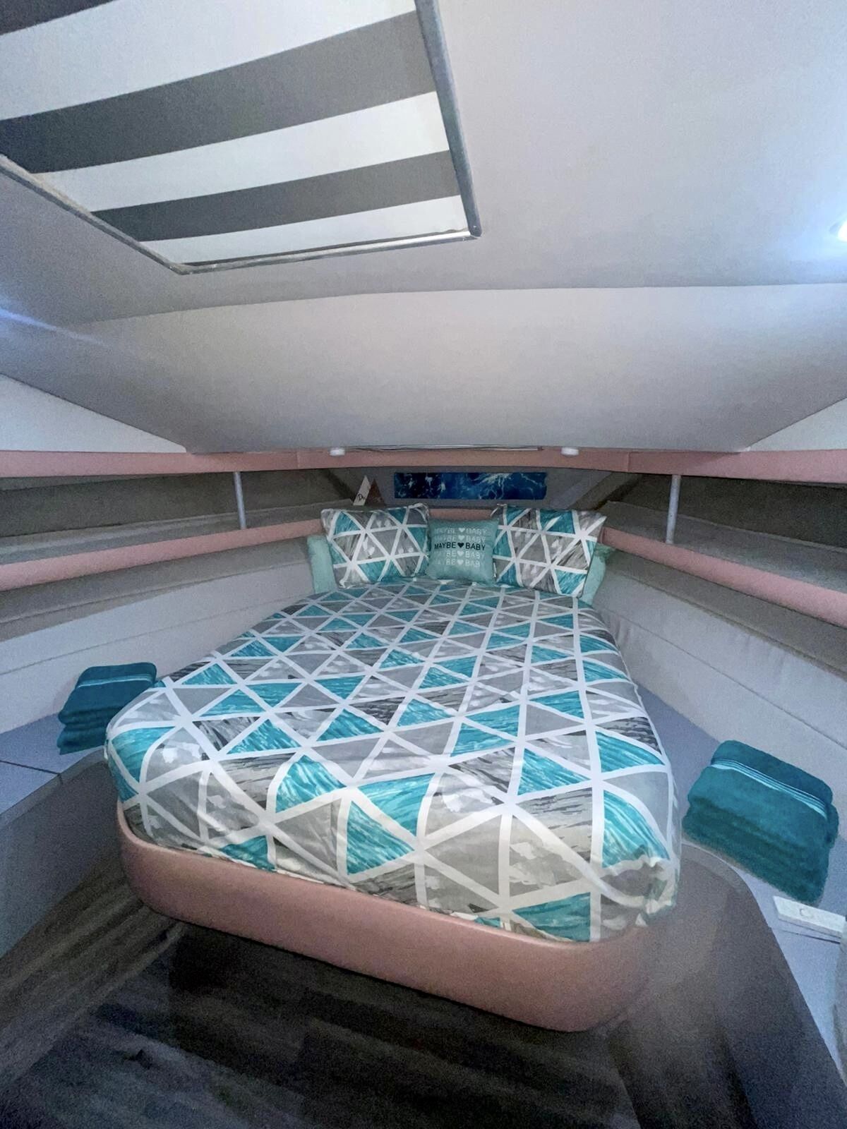 Habitació petita i senzilla amb llit, almoines i una petita estant.