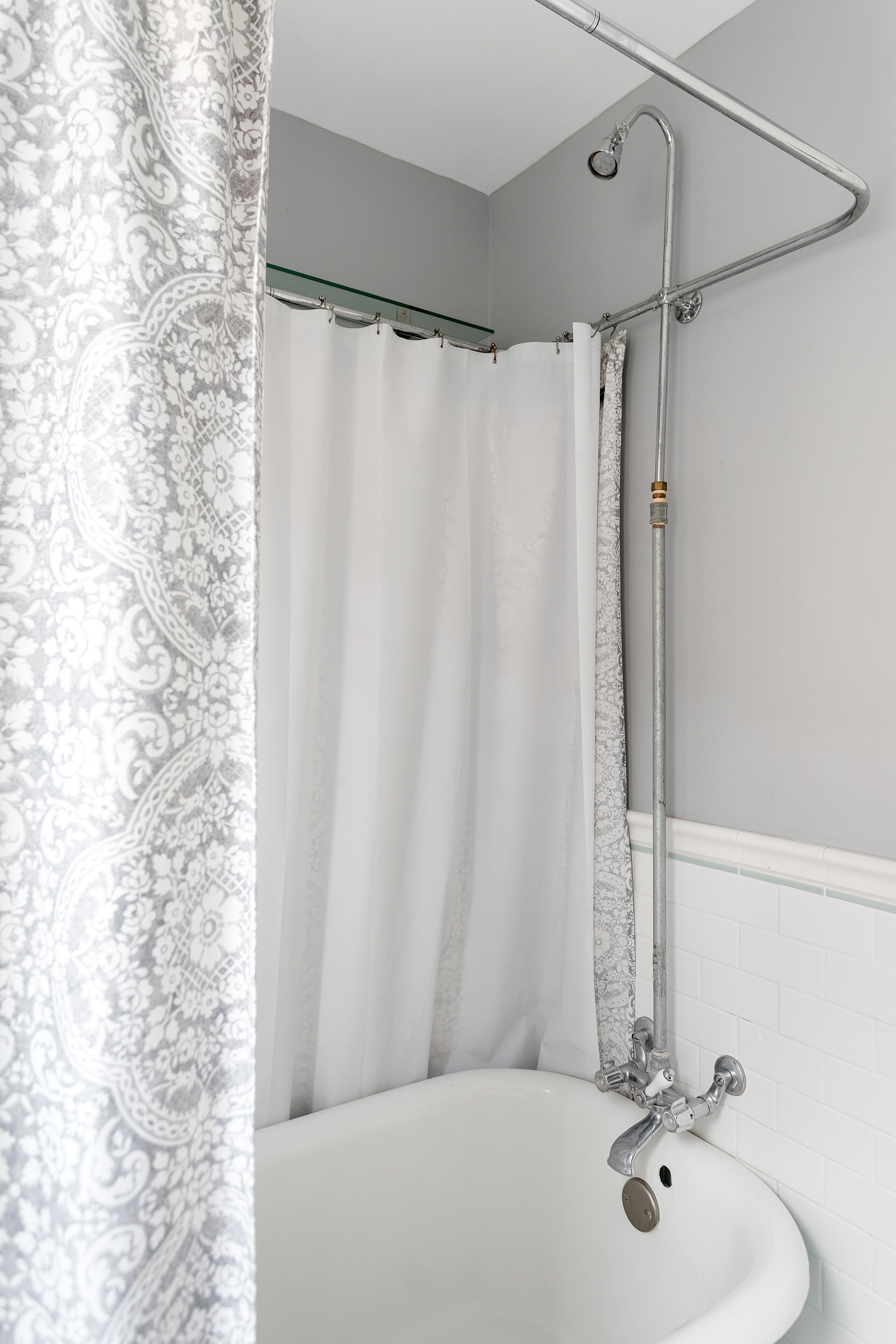 A bathroom with a bathtub, a shower, and a curtain.