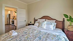 Un dormitorio con una cama grande, cabecera de madera y una planta en maceta.