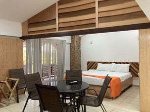 Cozy retreat with a single bed, dining area, and balcony offering a view of the outdoors.
