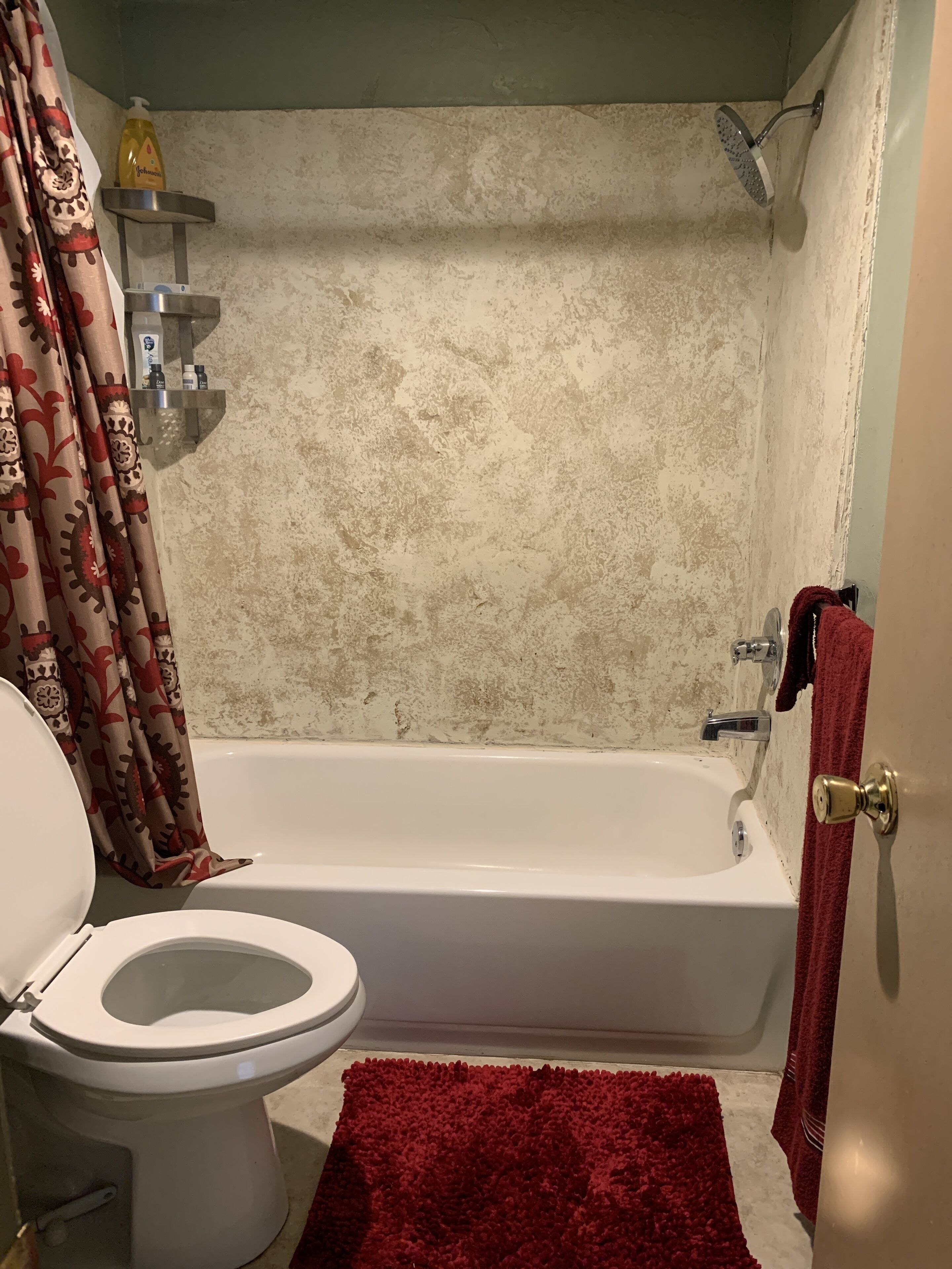 A bathroom with a bathtub, toilet, and shower.