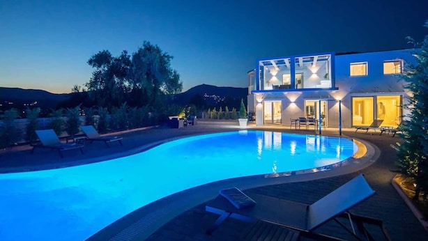 A modern house with a swimming pool, outdoor seating, and a mountain view. - Luxury villa with 2 pools , jacuzzi and tennis court (Corfu)