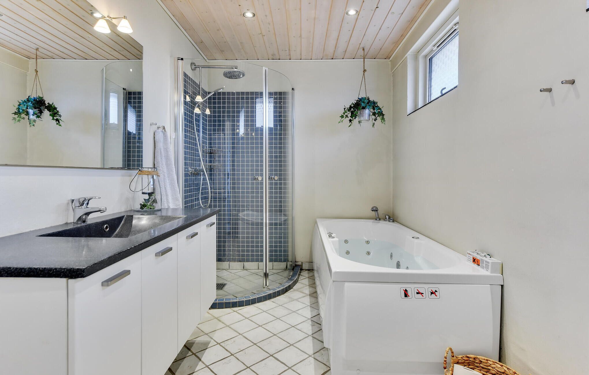 Un baño moderno con ducha, bañera y lavamanos.