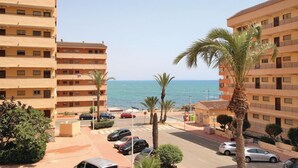 A coastal residential area with multi-story buildings, a parking lot, and a view of the sea. - Cozy apartment in Torrevieja with house sea view (Torrevieja)